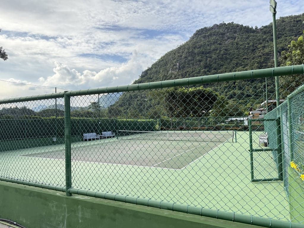 Che Elpend tennis court through the perimeter fence
