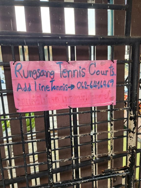 Hand-written Rungsang Tennis Courts sign with a LINE contact number on the gate